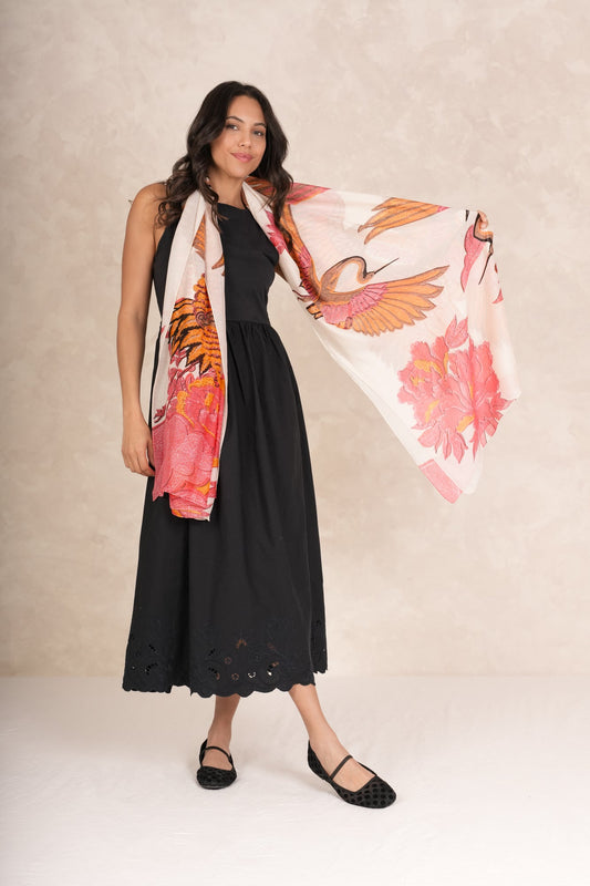 Woman wearing a black dress with a floral scarf draped over her shoulders against a beige background.
One Hundred Stars Crane Ecru Scarf