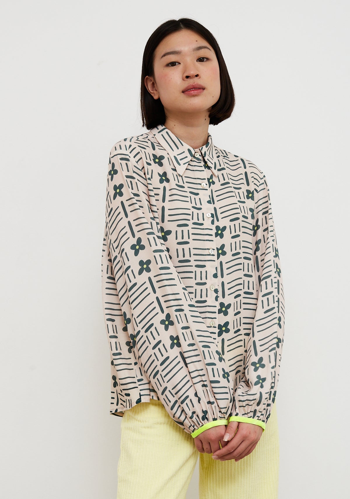 Person wearing a patterned shirt with a plain background