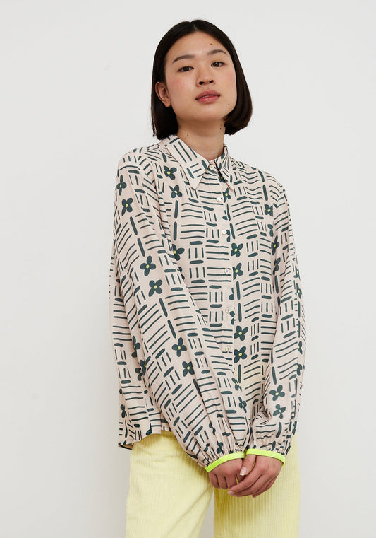 Person wearing a patterned shirt with a plain background