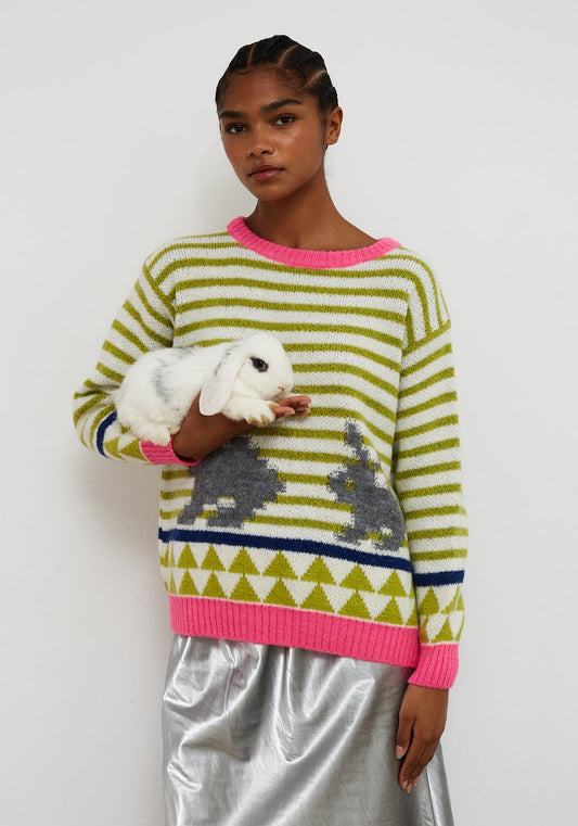 Dr Bloom Jersey Rabbit Green. Person wearing a colourful striped sweater with bunny designs, holding a small white rabbit.