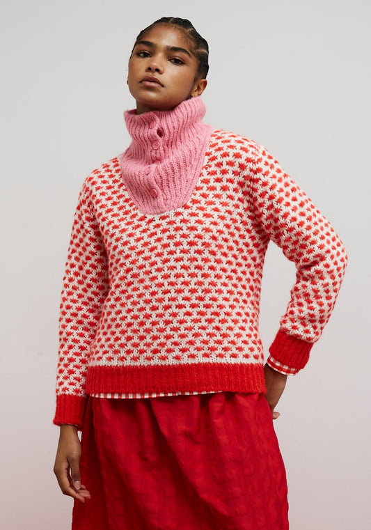 Dr Bloom Optimist Pink Jersey. Person wearing a red and white patterned sweater with a pink knitted cowl against a light background