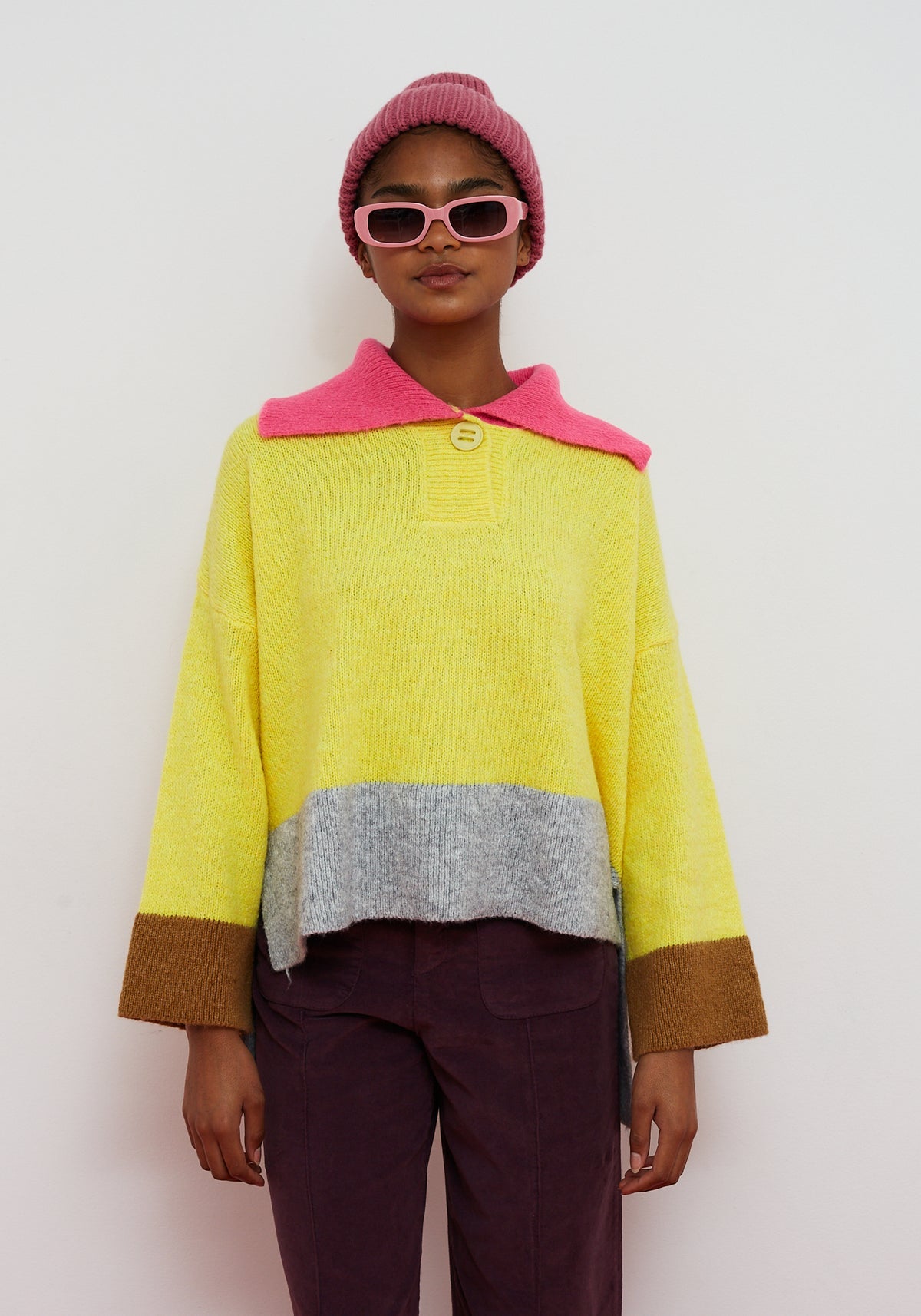 Dr Bloom Yellow Sail Jersey. Person wearing a colourful sweater with a pink collar and a white background
