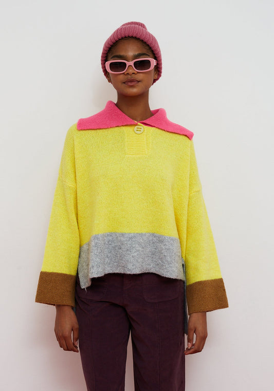 Dr Bloom Yellow Sail Jersey. Person wearing a colourful sweater with a pink collar and a white background