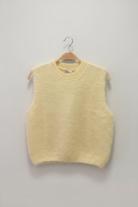 Light yellow sweater on a hanger against a plain background