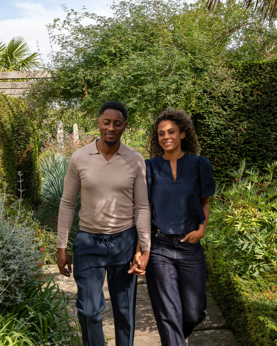 Two people holding hands in a garden setting