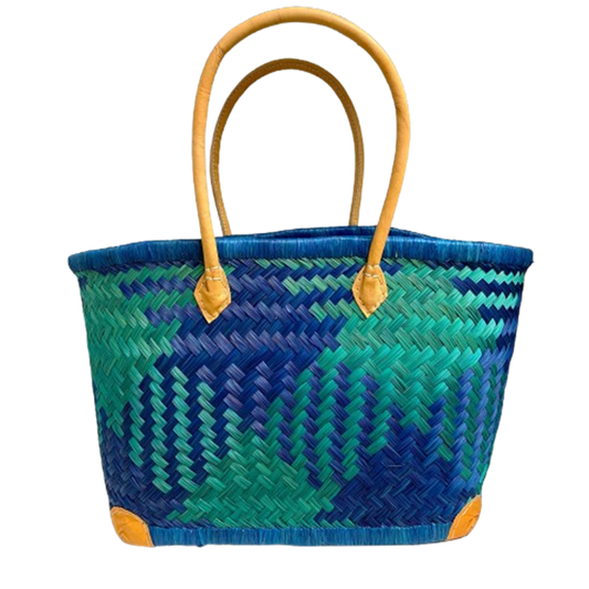 Woven basket with blue and green pattern and yellow handles on a white background