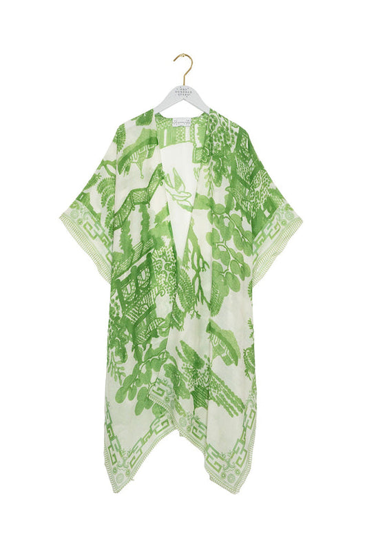 Green and white patterned kimono on a hanger against a white background