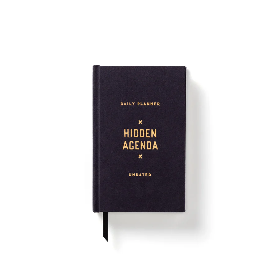 Black daily planner with 'Hidden Agenda' branding on a white background