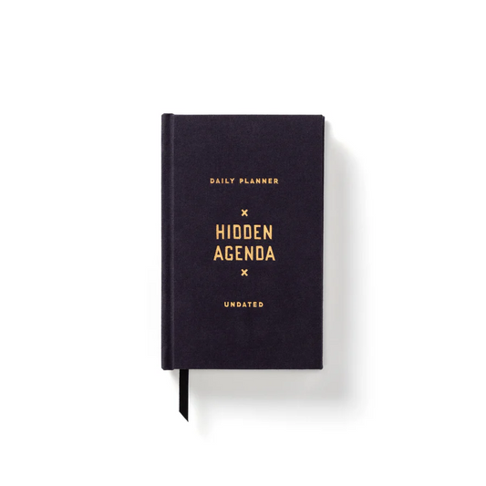 Black daily planner with 'Hidden Agenda' branding on a white background