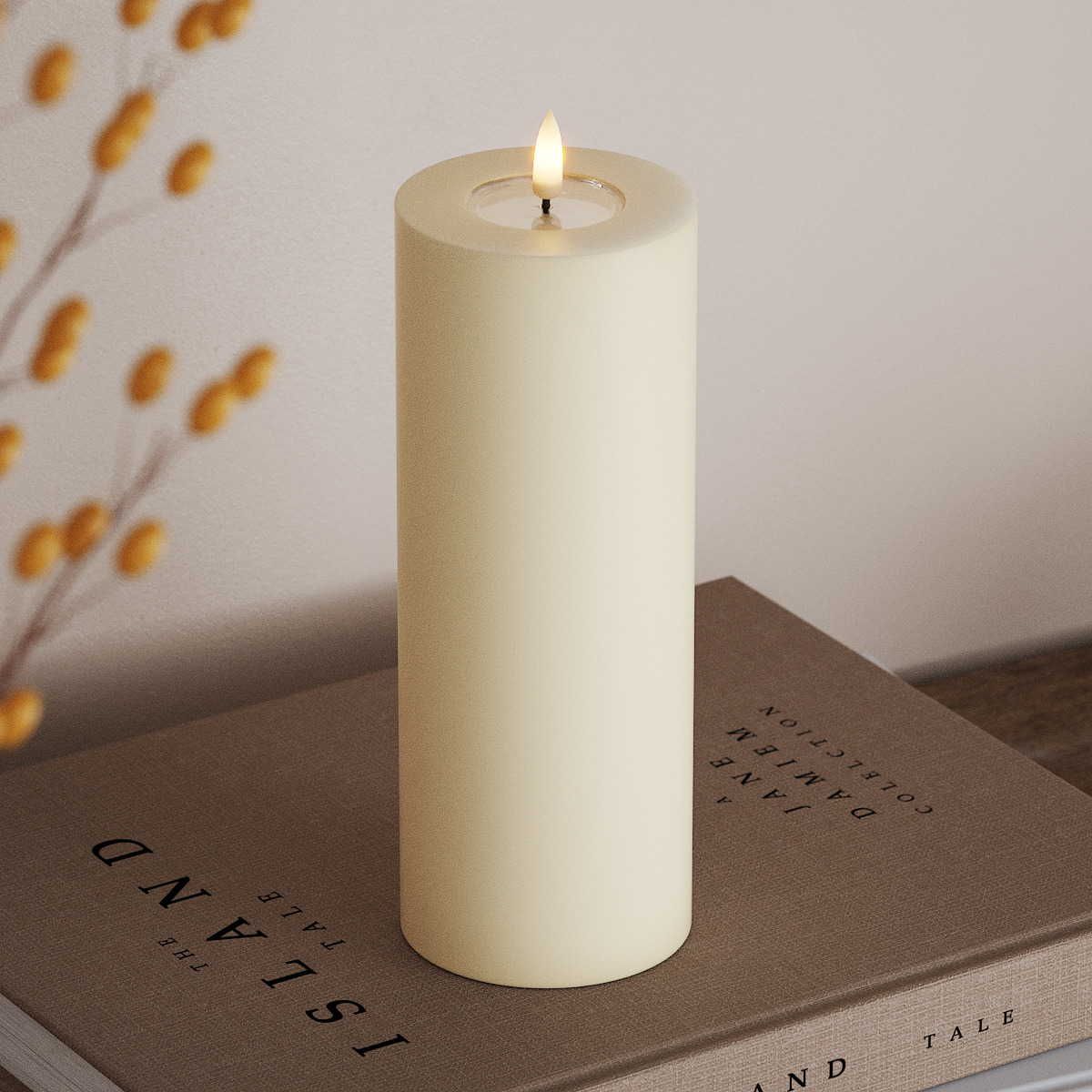 Cream candle with a flame on a book next to a branch with yellow berries.