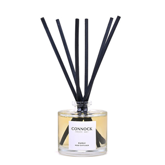 Connock London Kuskii Reed Diffuser with a clear glass bottle, pale amber liquid, and six black reeds, shown on a white background.