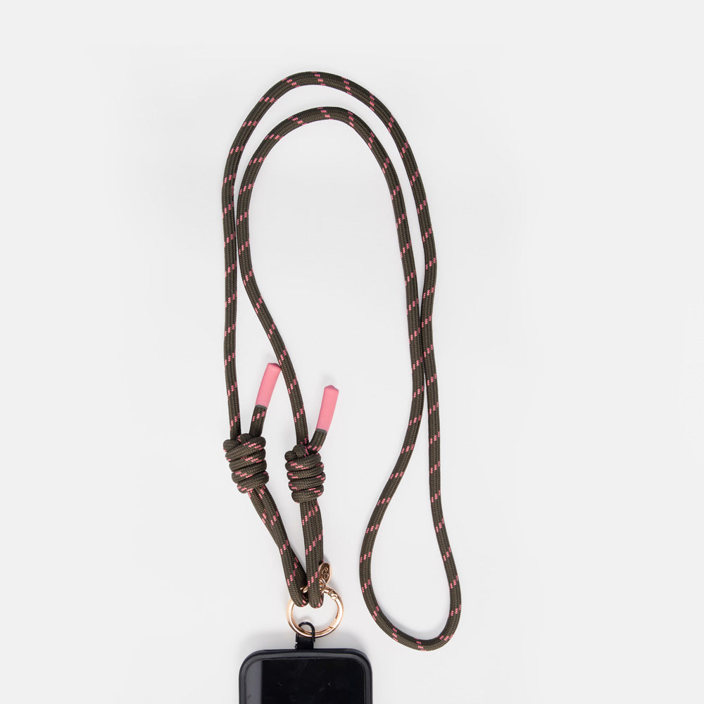 A dark brown paracord lanyard with a subtle red pattern, featuring pink-tipped knots and a gold metal ring at the bottom, holding a black rectangular device, shown on a light gray background.