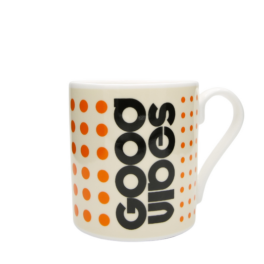 Mug with 'GOOD VIBES' text and orange polka dots on a white background