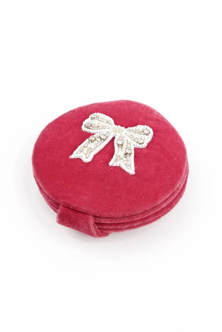 Red round jewelry box with a decorative bow on a white background