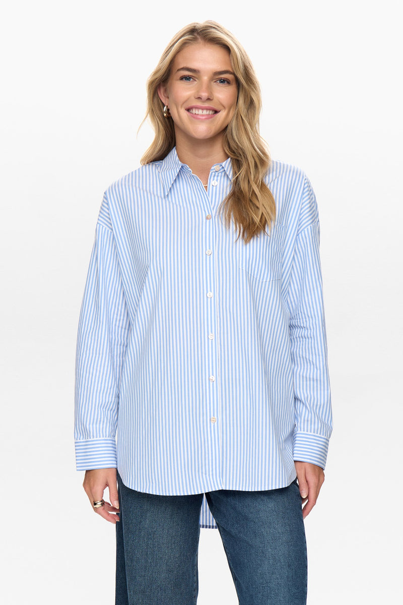 Woman wearing a blue and white striped shirt against a white background