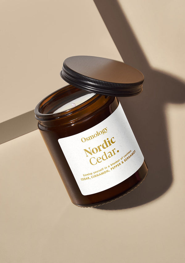 Brown candle jar with 'Nordic Cedar' label on a beige background