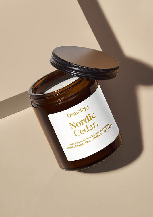 Brown candle jar with 'Nordic Cedar' label on a beige background