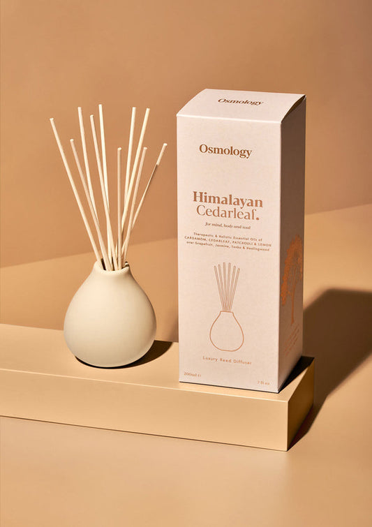 Osmology Himalayan Cedarlicial diffuser with packaging on a beige background