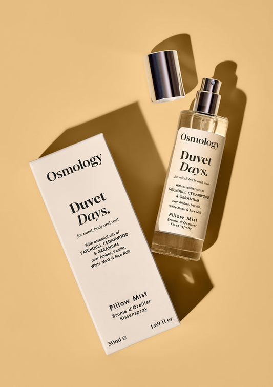 Osmology Duvet Days pillow mist bottle and packaging on a beige background