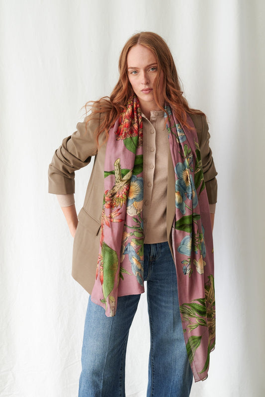 Woman wearing a colorful floral scarf with a neutral background
