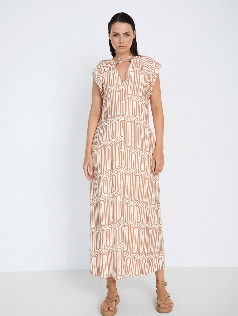 Woman wearing a patterned dress on a white background