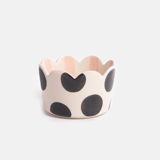 Ceramic bowl with black polka dots and a pink rim on a white background