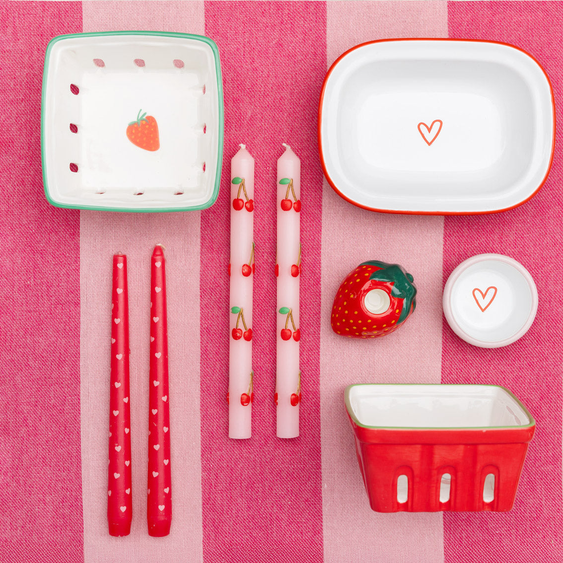 Table setting with red and white ceramic items on a pink checkered tablecloth