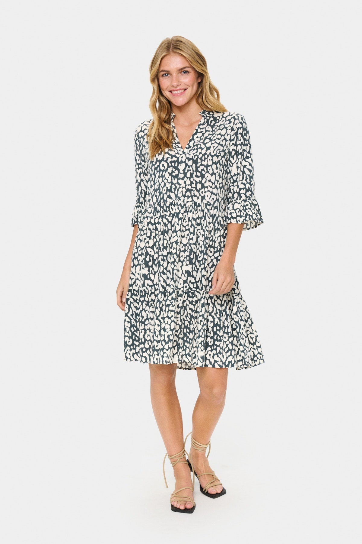 Saint Tropez Eda Dress in Winter Urban Chic Leopard. Woman wearing a black and white patterned dress on a white background
