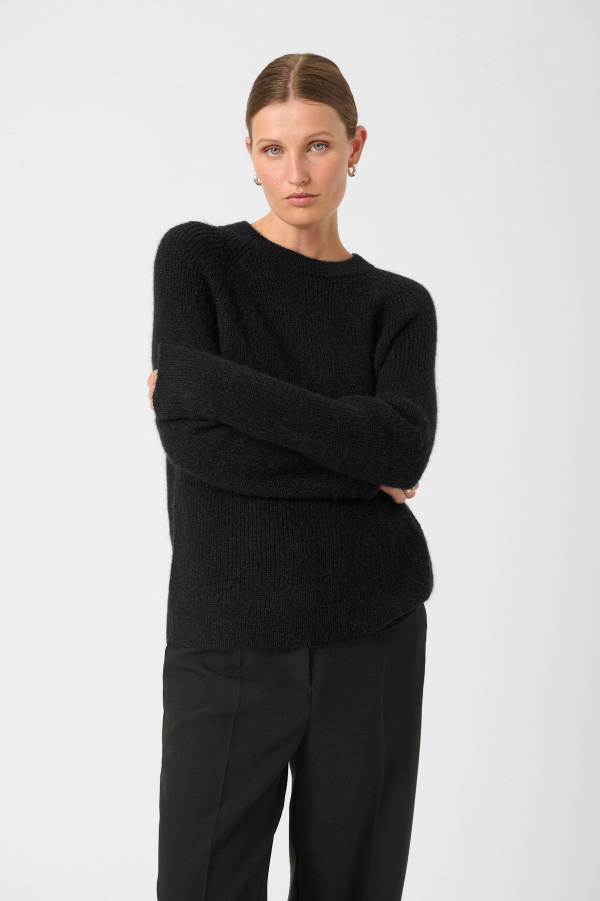 Soaked in Luxury Tuesday Jumper in Black. Person wearing a black sweater and pants on a white background