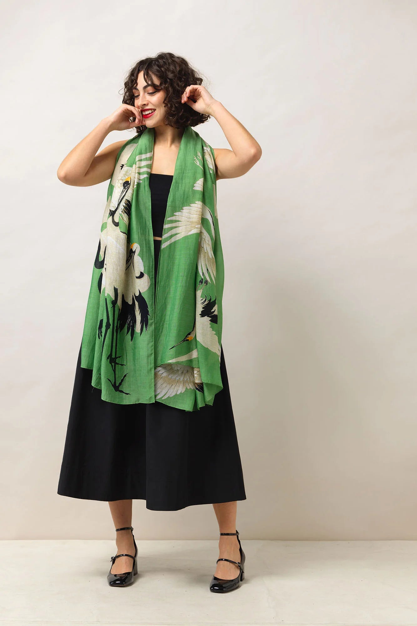 Stork green scarf with black dress and shoes and a neutral background