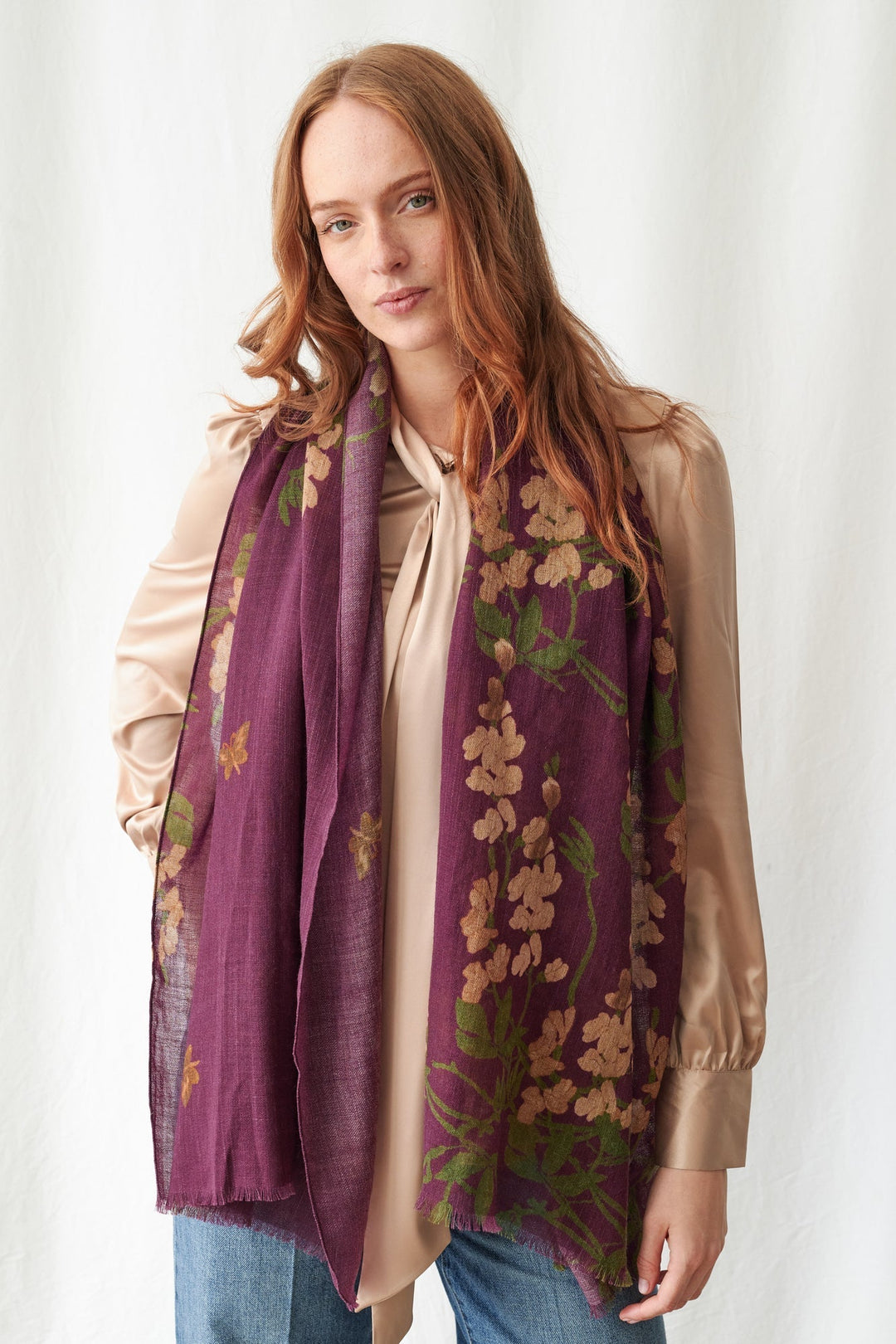 Woman wearing a purple floral scarf against a white background