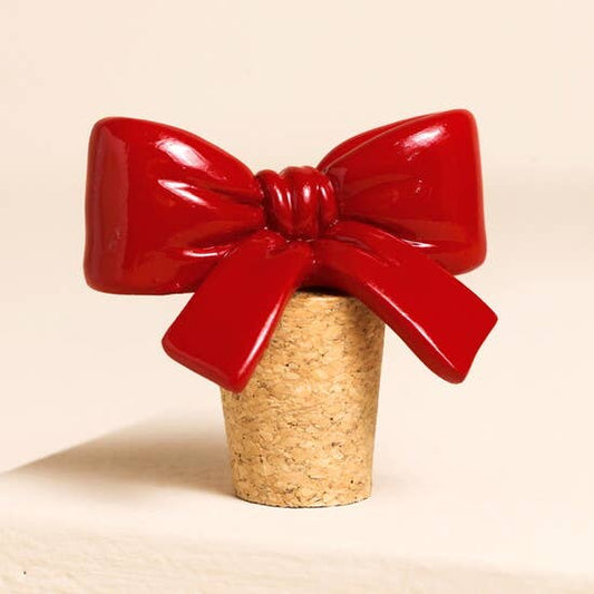 Cork bottle stopper with a large red bow on a beige background
