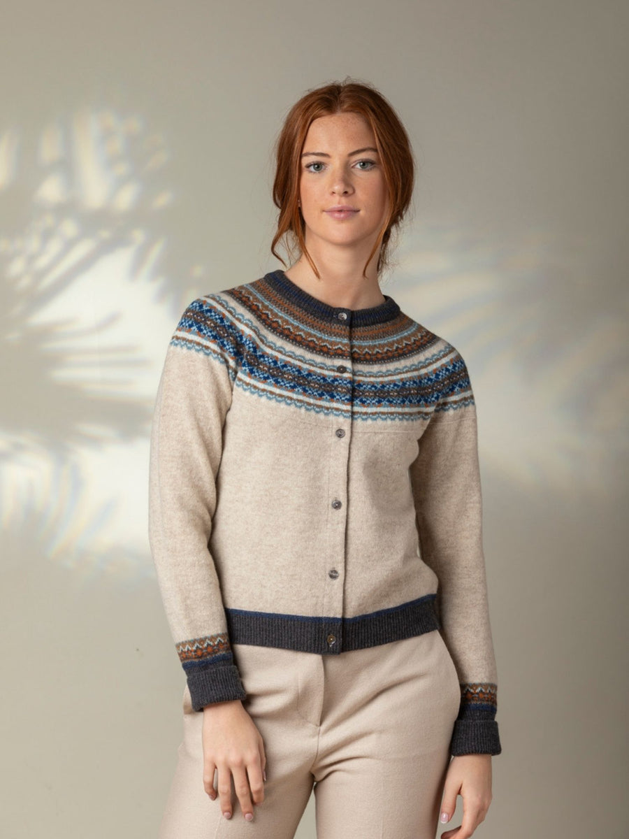 Eribe Alpine Short Cardigan in Taurus - Woman wearing a patterned sweater with a neutral background