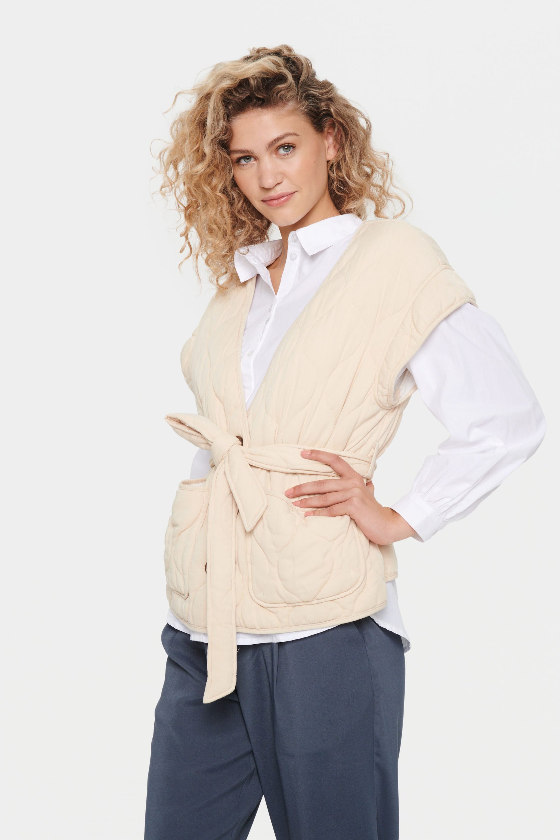 stylish, quilted cream coloured waistcoat with large pockets, self fabric tie and buttons to fasten