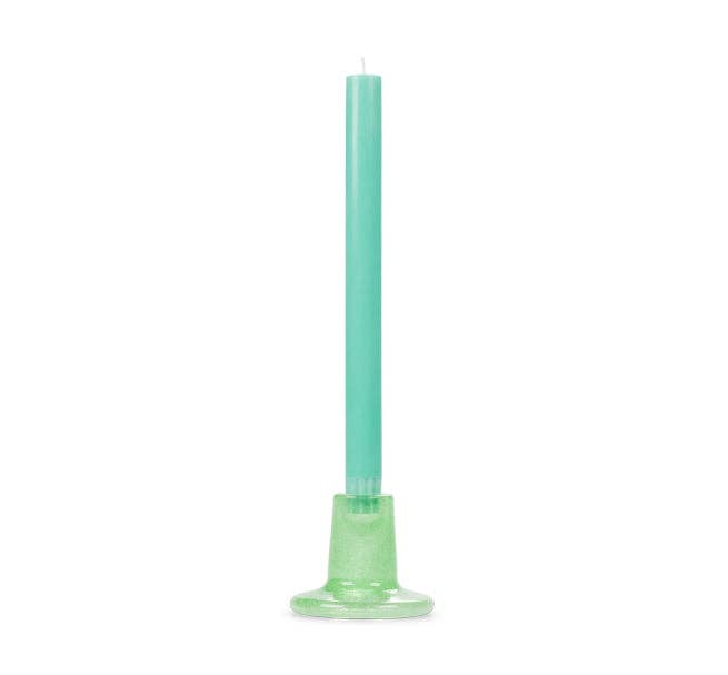 Green candle with a decorative base on a white background