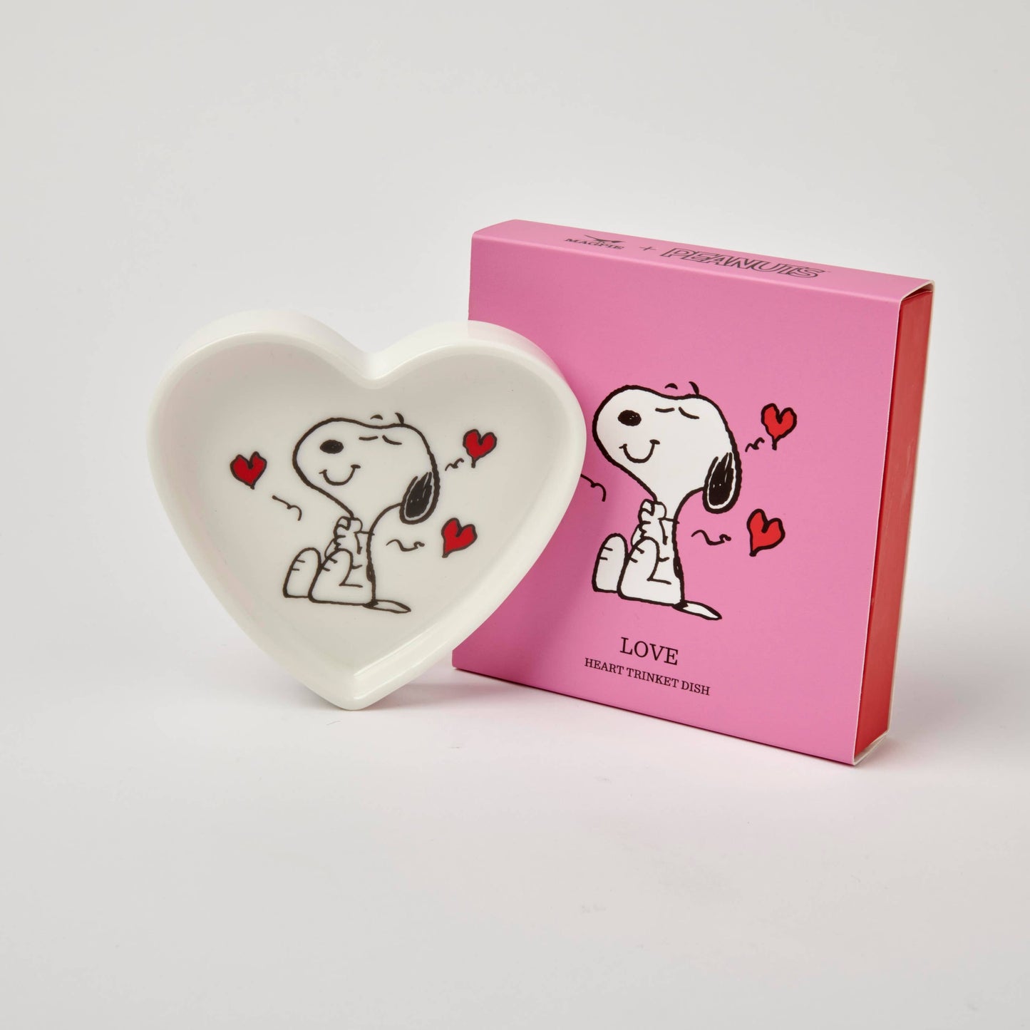 Heart-shaped dish with Snoopy design next to a pink box on a white background