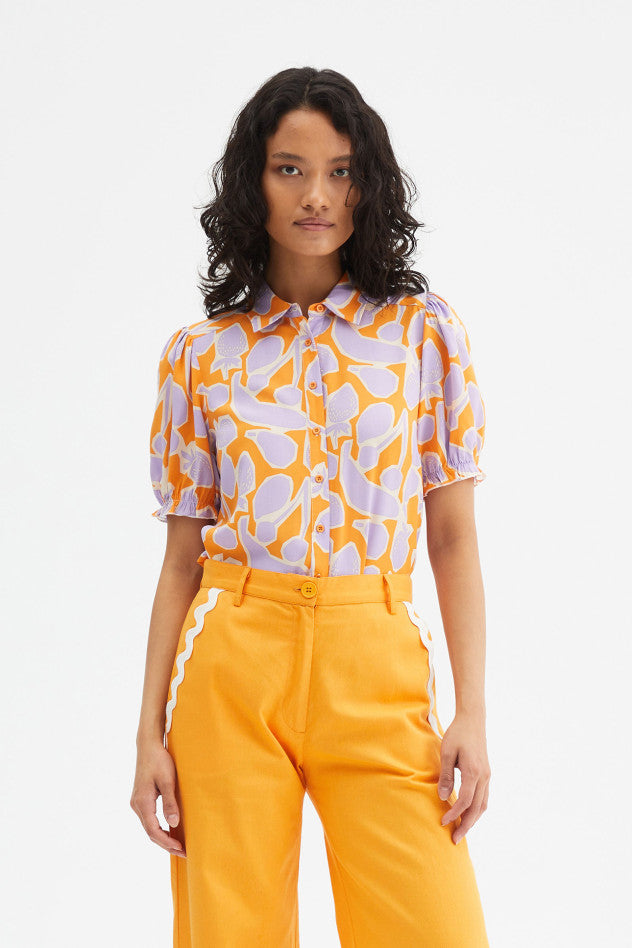 Fruit print short sleeve shirt paired with bright orange trousers