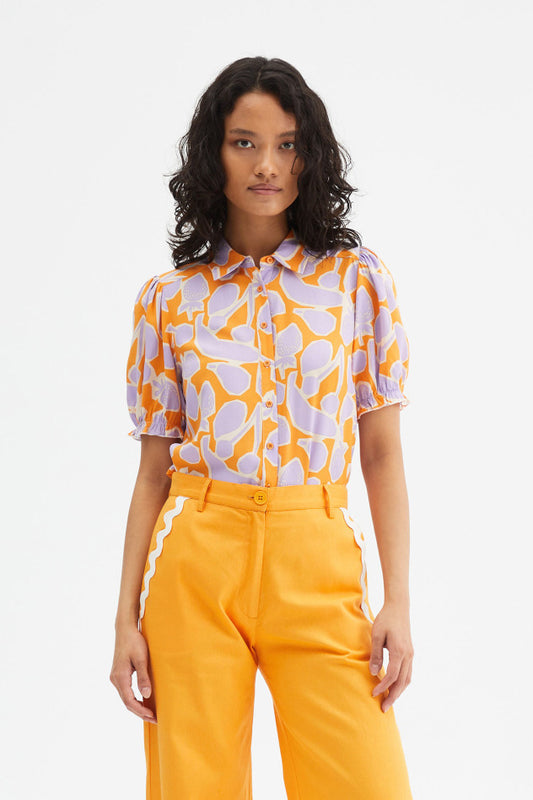 Fruit print short sleeve shirt paired with bright orange trousers