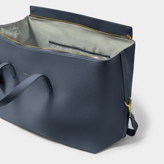 Navy blue leather bag with gold zipper on a light gray background
