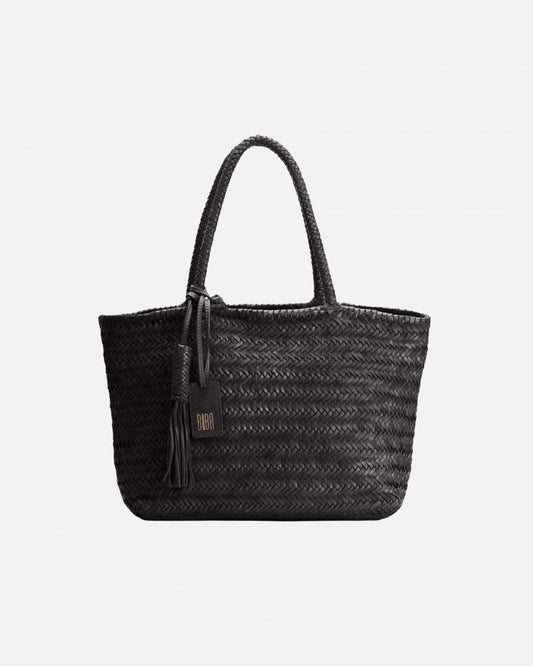 Black woven handbag with a tassel on a light gray background