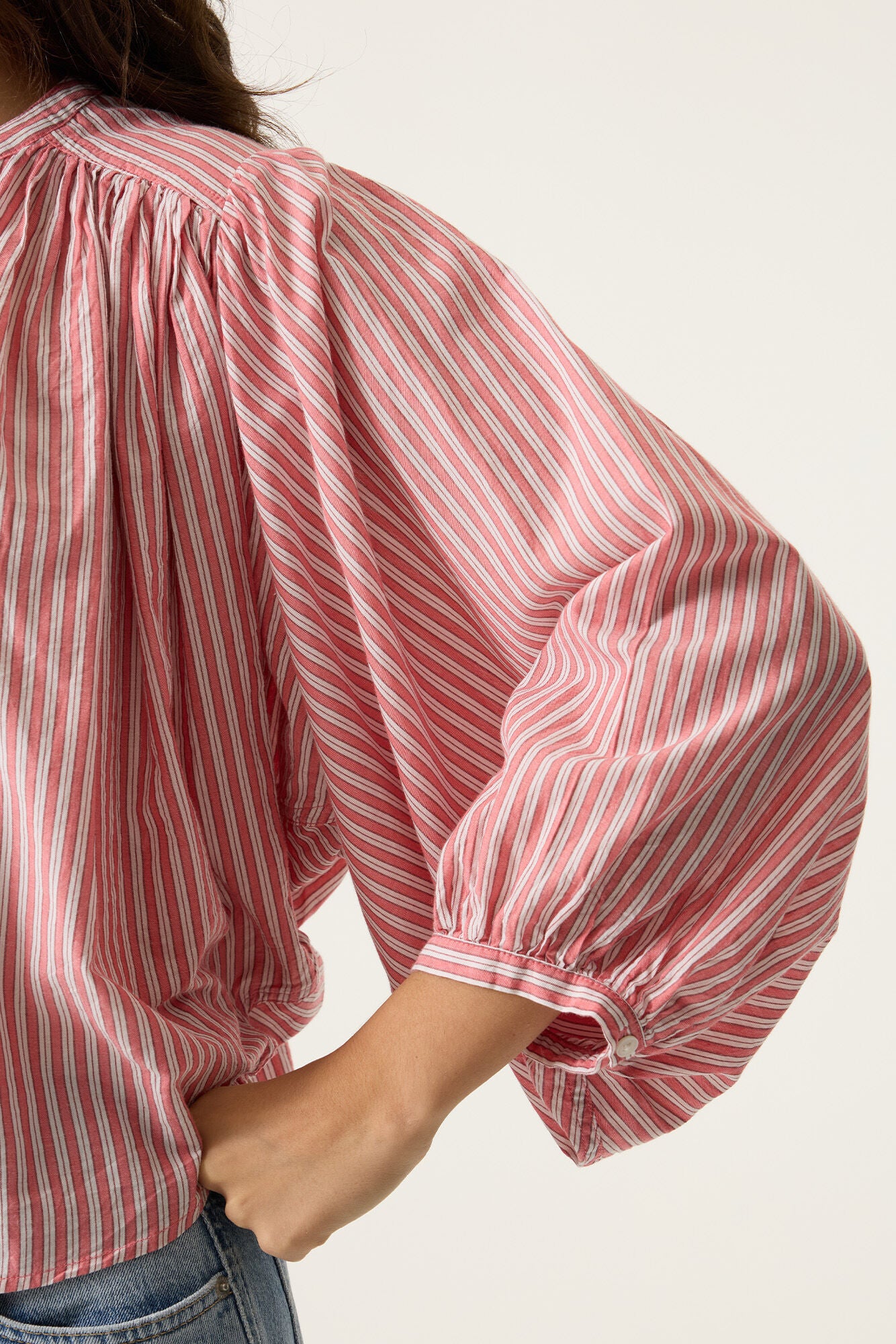 Red and white striped blouse with puffed sleeves on a plain background
