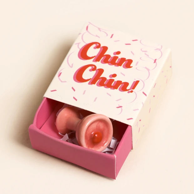 Pink packaging with a product inside and 'Chin Chin!' text on a beige background