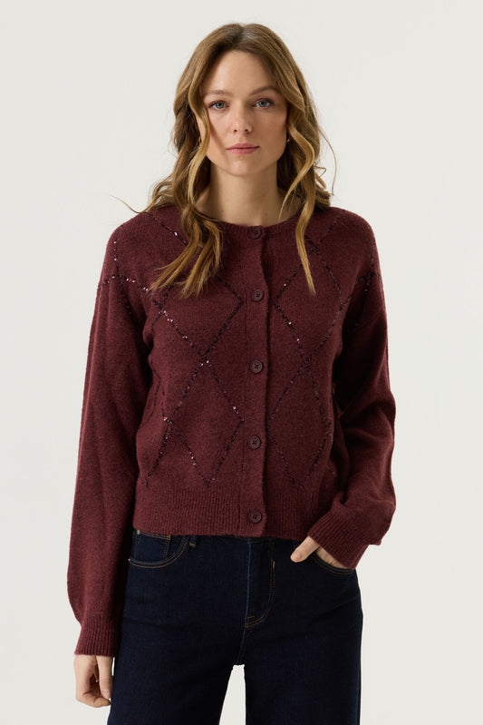 Garcia Bordeaux Red Cardigan - A woman wearing a burgundy knit cardigan with dark buttons and subtle sequined diamond patterns, paired with dark blue jeans, against a plain light grey studio background.
